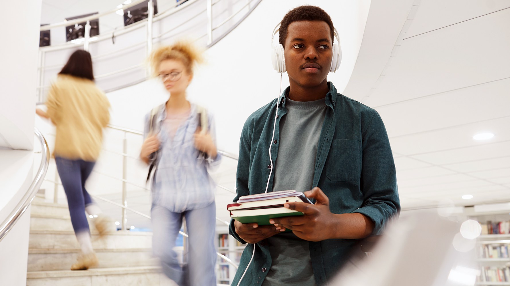 Ein Student steigt in der Bibliothek eine Treppe hinunter