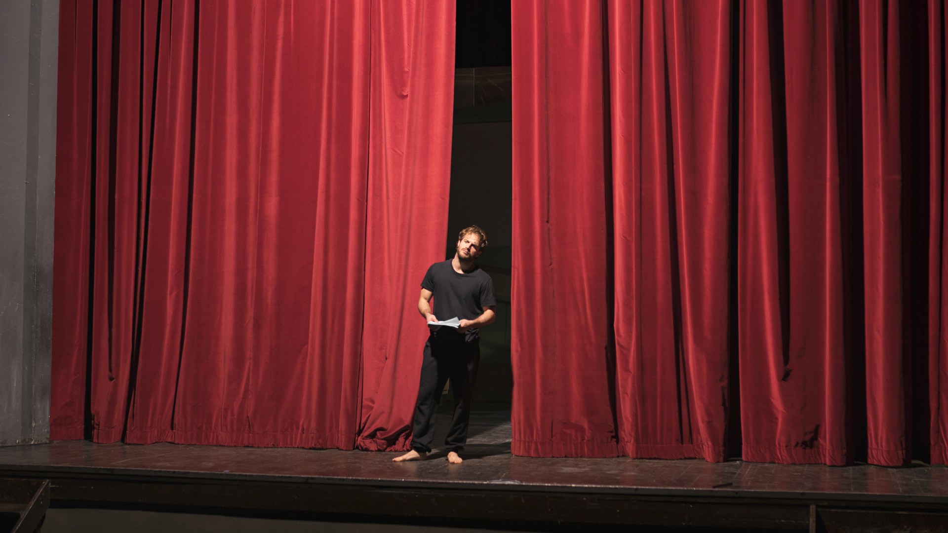 Barfussschauspieler mit Drehbuch auf Theaterbühne